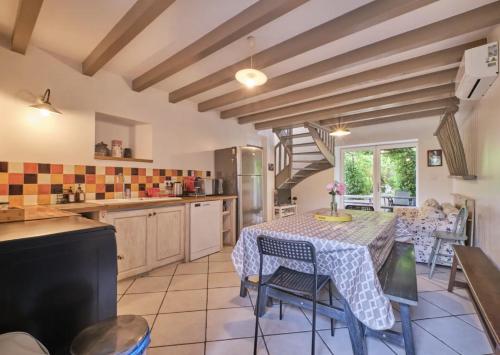 - une cuisine avec une table, des chaises et une table dans l'établissement Gîte de charme entre campagne et montagne, à Corbelin