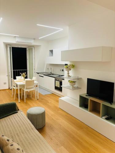 a kitchen and living room with a couch and a television at La Mombellina OLTRE HOME HOLIDAYS in Sanremo