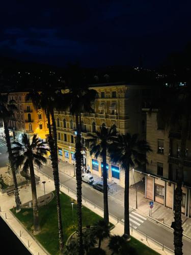a group of palm trees in front of a building at La Mombellina OLTRE HOME HOLIDAYS in Sanremo