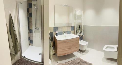 a bathroom with a sink and a shower and a toilet at La Mombellina OLTRE HOME HOLIDAYS in Sanremo