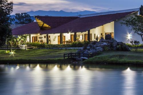 a house with a river in front of it at Hotel Brisas La Gaviota Mariquit-Tolima in Mariquita