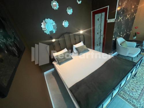 a bedroom with a bed and a chair at Villa Layar Selorejo Mitra RedDoorz in Malang