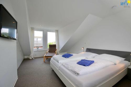 Un dormitorio con una cama con dos almohadas azules encima. en Ferienhaus Wangehüs, en Wangerooge