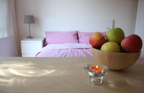 皮尔纳Gemütliches Doppelzimmer in Landhaus mit Garten und Terrasse的桌上有一碗苹果和一支蜡烛