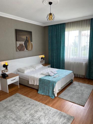a bedroom with a large bed and a window at TULİPA SUİTEs TRABZON in Bostancı