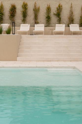 a swimming pool with some chairs and some blue water at 3 Olives House - by 3 Marias Residence in Santana