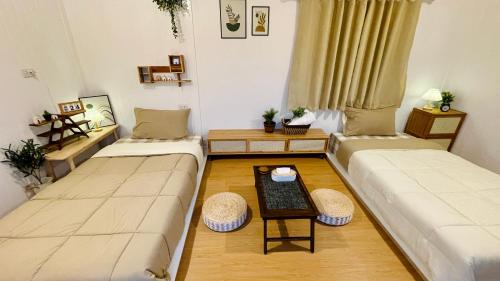 a living room with two couches and a table at บ้านไร่ฟ้าสวย Nordic 02 in Ban Kom
