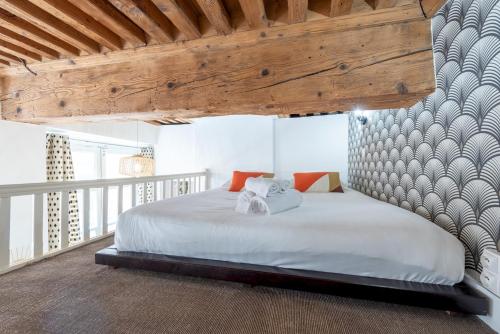 une chambre avec un grand lit avec un plafond en bois dans l'établissement Le Chérubin - Appt en pleins coeur de Lyon, à Lyon