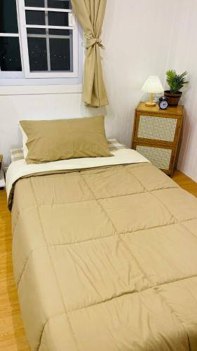 a large bed in a bedroom with a window at บ้านไร่ฟ้าสวย Nordic 02 in Ban Kom