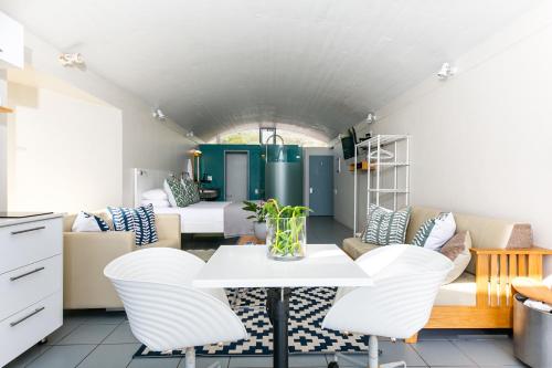 a room with a table and chairs and a bedroom at Speelhuis Collection in Langebaan