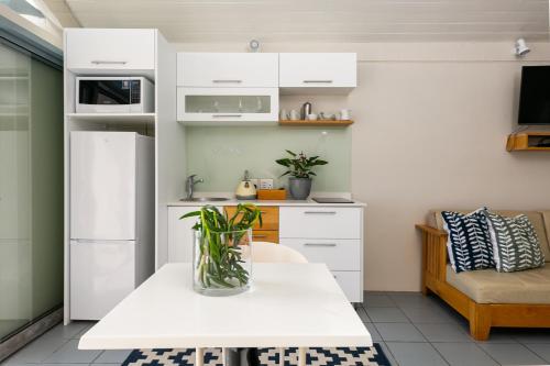 a kitchen with white cabinets and a vase on a table at Speelhuis Collection in Langebaan
