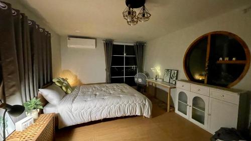a bedroom with a bed and a large mirror at บ้านไร่ฟ้าสวย Nordic 02 in Ban Kom