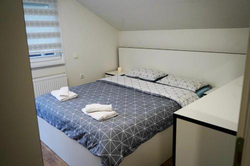 a bedroom with a bed with two towels on it at Villa Tasnim in Dobrenica