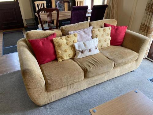 a couch with pillows on it in a living room at Livingstones Lodge, Lake District in Plumbland