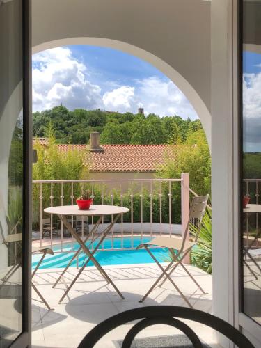 un patio avec une table et des chaises sur un balcon dans l'établissement Studio avec loggia, piscine et parking, à Montferrier-sur-Lez