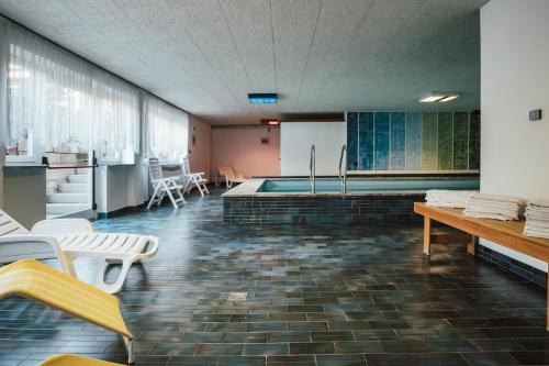 a room with a pool and a table and chairs at Hotel Residence Griesfeld in San Giovanni