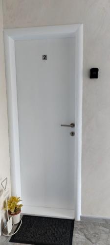 a white door with a black rug in a room at APARTMENTS IVANOViC CENTER CITY in Bajina Bašta