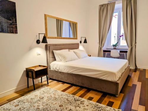 Un dormitorio con una cama y un espejo en la pared. en Luxury Gallery Suites, en Roma