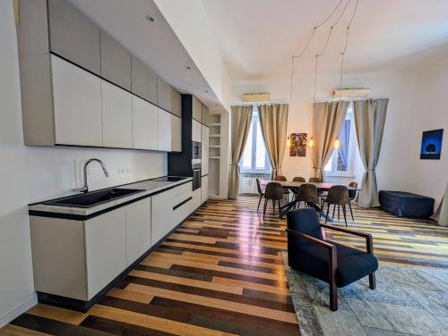 Una cocina con gabinetes blancos y una mesa con sillas. en Luxury Gallery Suites, en Roma
