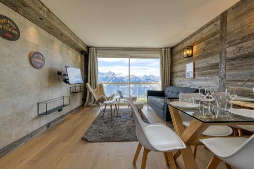 un salon avec un canapé, une table et des chaises dans l'établissement Homency - Résidence Signal C23, à L'Alpe-d'Huez