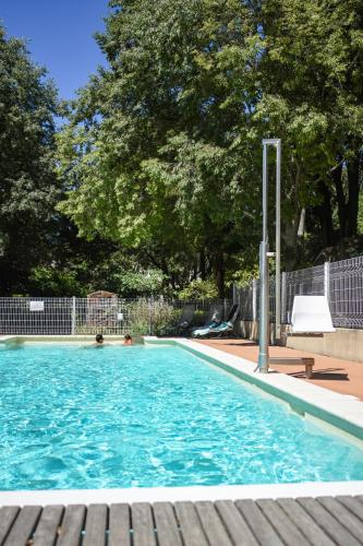 une piscine avec de l'eau bleue dans une cour dans l'établissement Ethic étapes le Cart, à Sommières