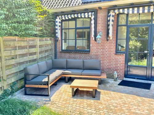 a couch and a coffee table on a patio at Luxury home in quiet neighbourhood near beach in The Hague