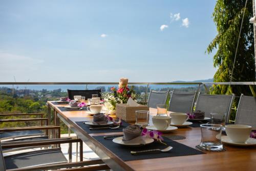 - une table avec des assiettes et des tasses sur le balcon dans l'établissement Villa Beyond 9 Bedrooms Seaview - Full Services, à Bang Tao Beach