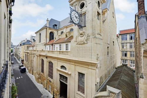 un bâtiment avec une horloge sur le côté dans l'établissement GuestReady - Charming stay near Sainte-Chapelle, à Paris