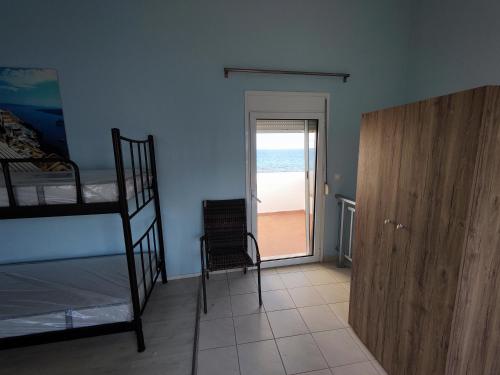 a bedroom with bunk beds and a door to the beach at Seaside house in Sozopoli