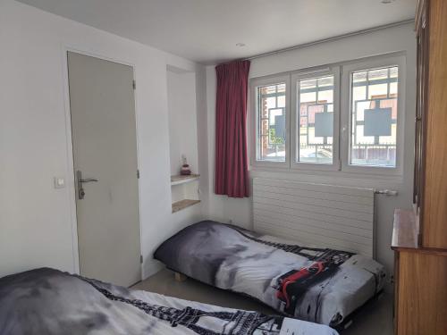 une chambre avec deux lits et une fenêtre dans l'établissement House 20 min from Paris by metro, free parking, à Créteil