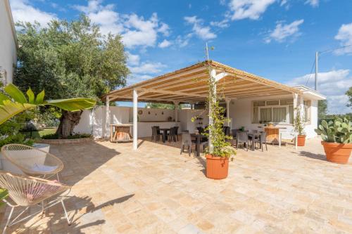 a patio with a pavilion with chairs and a table at Dimora Tauro B&B in Fasano