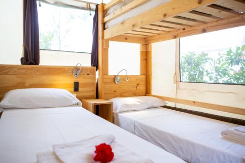 a room with two beds and a window at Camping Del Sole Village in Iseo