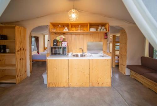 a kitchen with wooden cabinets and a sink in a room at Camping Del Sole Village in Iseo
