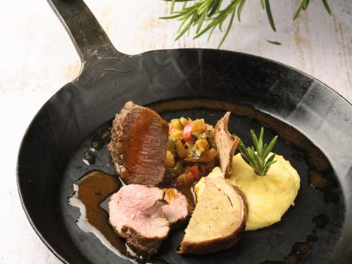 a plate of food with meat and bread in a pan at VitalZeit Hotel Weber in Bad Schönau