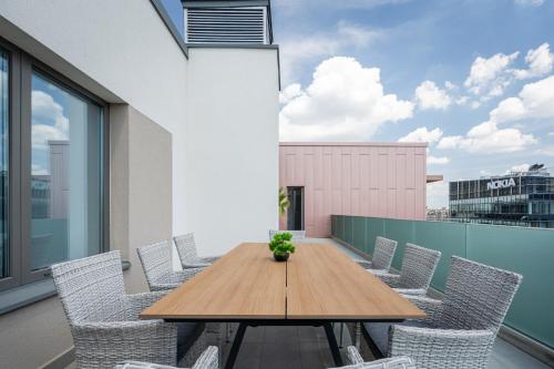 a wooden table and chairs on a balcony at Corvin 5 Stars Luxury Apartment with Free Parking in Budapest
