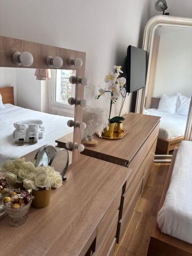 - une chambre avec une commode en bois et un miroir dans l'établissement Charmant et cozy au centre de Paris Montmartre, à Paris