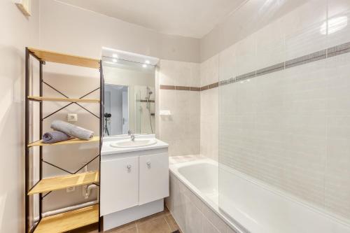 une salle de bain avec un lavabo, une baignoire et une douche dans l'établissement Appartement Cosy & Moderne 2 chambres, à Saint-Denis