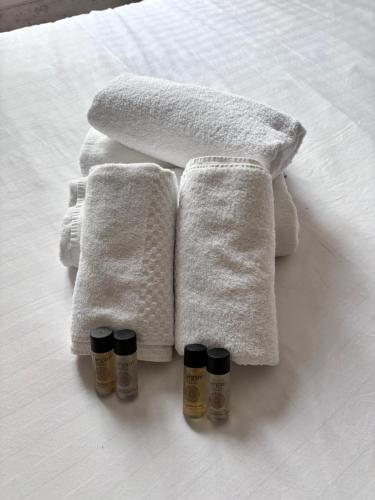 - deux serviettes et deux bouteilles d'huiles essentielles sur un lit dans l'établissement Charmant et cozy au centre de Paris Montmartre, à Paris