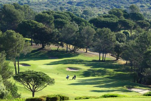 two people playing golf on a golf course at Le Domaine de Saint Endreol Golf & Spa Resort in La Motte