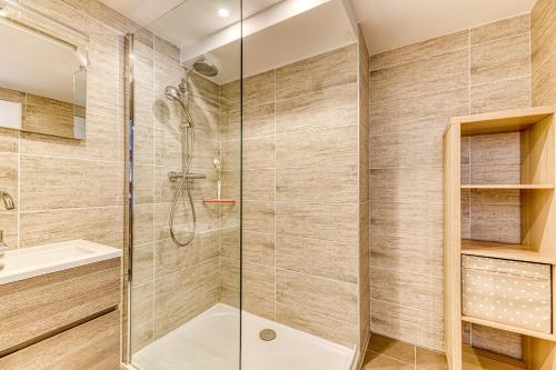 une salle de bain avec douche et lavabo dans l'établissement Homency - Résidence Les Mélèzes 14, à L'Alpe-d'Huez