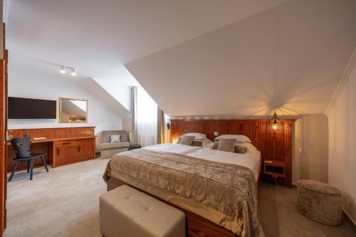 a bedroom with a large bed and a desk at Kotnik Superior Boutique Hotel in Kranjska Gora