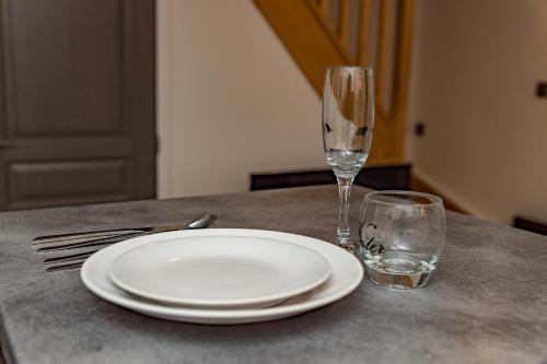 a white plate and two glasses on a table at Paradis des bulles in Châteaudun