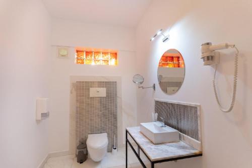 a bathroom with a sink and a toilet and a mirror at Villa Pontica in Mamaia Sat/Năvodari