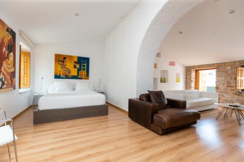 a bedroom with a bed and a couch and a chair at Hotel Nou Romà in Denia