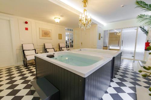 a large bath tub in a room with a checkered floor at Boutique Hotel Teatro in Angra do Heroísmo