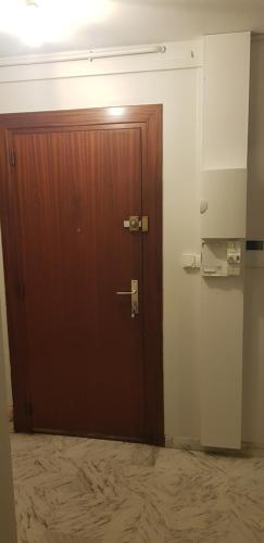 une porte marron dans une chambre avec un mur dans l'établissement Appartement f3 , 2 chambres, à Béziers