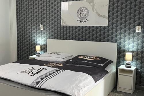 a bedroom with a bed with a black and white blanket at Adél Apartman in Kisújszállás