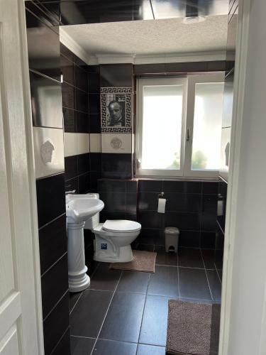 a bathroom with a toilet and a window at Adél Apartman in Kisújszállás