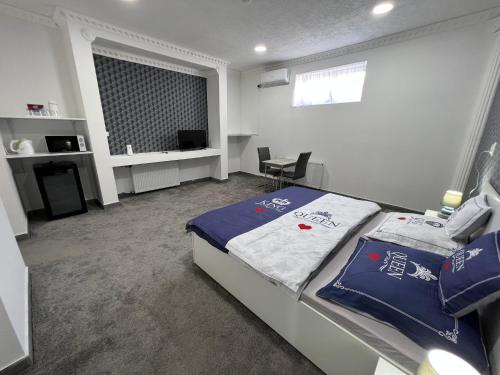 a bedroom with a bed with blue pillows in it at Adél Apartman in Kisújszállás