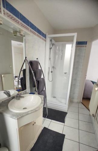 une salle de bain blanche avec un lavabo et une douche dans l'établissement Escapade en bord de mer, à Dunkerque